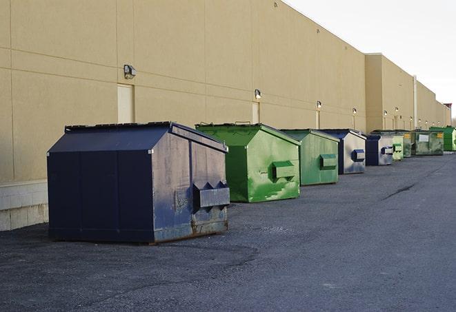 a construction worker moves construction materials near a dumpster in Esparto CA